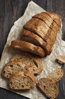 Sliced Rye Rustic Sourdough Bread on a Brown Paper. On a Wooden Table. T photo