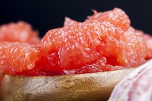 peeled red grapefruit divided into slices photo