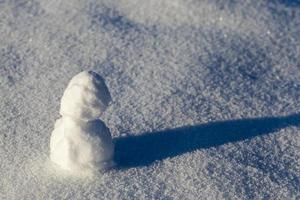un pequeño muñeco de nieve en la temporada de invierno, de cerca foto