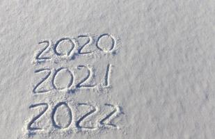 the inscription about the new year 2022 on the snow in winter photo