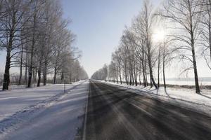 paved road covered with snow in winter photo