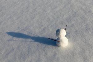 un pequeño muñeco de nieve en la temporada de invierno, de cerca foto