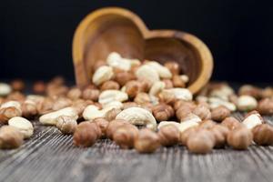 dry cashew nuts, hazelnuts and other dried fruits on an old wooden table photo