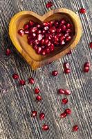 fresh pomegranate seeds in a heart shaped bowl photo