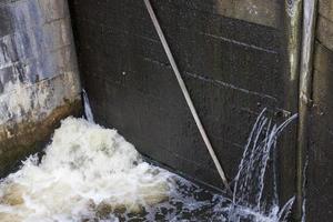 a leaking part of an old wooden dam photo