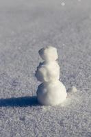 un pequeño muñeco de nieve en la temporada de invierno, de cerca foto