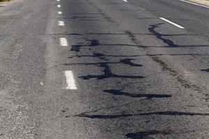 part of an asphalt road with damage photo