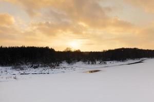 snow covered river at sunset photo