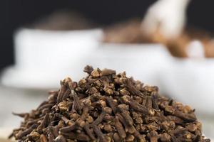 spices of cloves scattered on an old wooden table photo