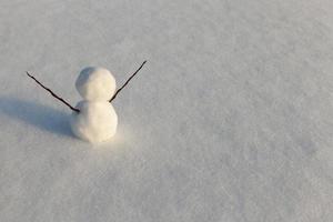 un pequeño muñeco de nieve en la temporada de invierno, de cerca foto