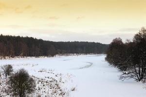 snow covered river at sunset photo