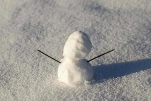 un pequeño muñeco de nieve en la temporada de invierno, de cerca foto