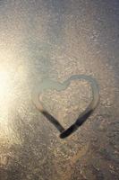 heart painted in winter on frozen glass, close up photo