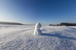 un pequeño muñeco de nieve en la temporada de invierno, de cerca foto