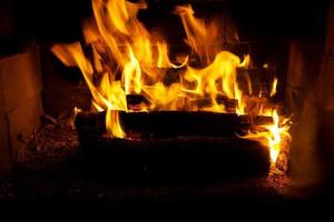 burning logs in the fire of a barbecue or stove or fireplace photo