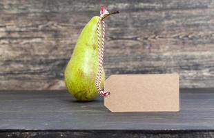 one green long old pear on a black photo