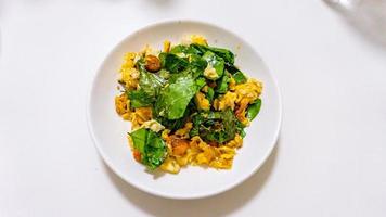 Stir-fried Malindjo Leaves with Egg on white plate photo