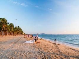 chon buri tailandia, 24 de diciembre de 2021, vista frontal de la vista bangsaen playa cielo azul palmera con atmósfera. los turistas disfrutan de los viajes de viaje y se relajan en la playa durante el atardecer de verano en vacaciones. foto
