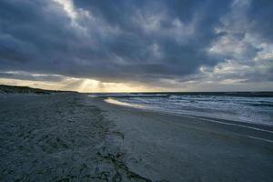 View over the dunes to the Baltic Sea at sunset photo