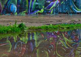 graffiti on a wall reflected in a puddle. photo