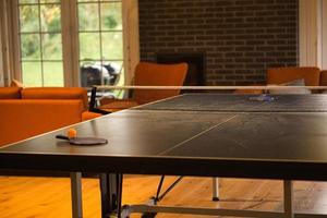 Table tennis bat with ball on a table tennis table. Pause before the game. photo