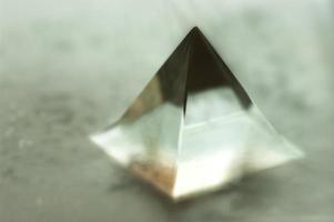 Blurry image of a glass pyramid. Abstract still life image of a geometric object. photo