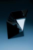 Abstract geometric object on dark blue background. Abstract minimalist image of a shiny object. photo