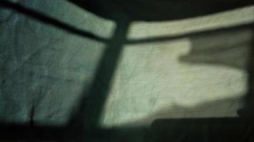 sombra de una ventana en un trozo de tela por la mañana. concepto de luz y sombra. foto
