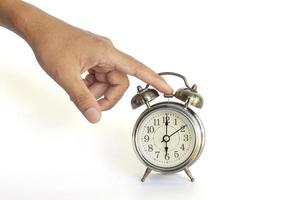 Hand of men turning off the alarm clock isolated on white background included clipping path. photo