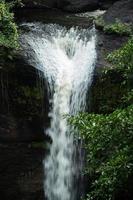 A natural waterfall in a big forest in the midst of beautiful nature. photo