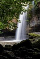 A natural waterfall in a big forest in the midst of beautiful nature. photo