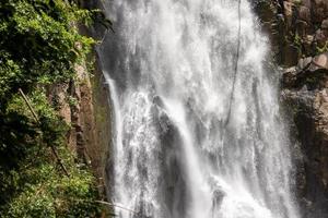 A natural waterfall in a big forest in the midst of beautiful nature. photo