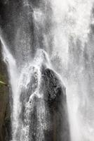 A natural waterfall in a big forest in the midst of beautiful nature. photo