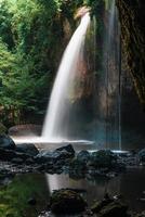 A natural waterfall in a big forest in the midst of beautiful nature. photo