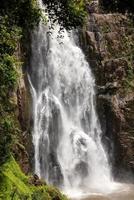 A natural waterfall in a big forest in the midst of beautiful nature. photo