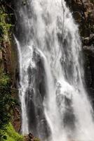 A natural waterfall in a big forest in the midst of beautiful nature. photo