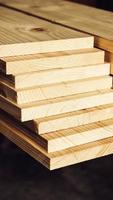 Stacked wooden carpentry boards from natural wood in a woodworking industry photo