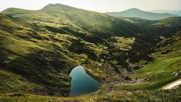 Carpathian lake Brebeneskul and rocky terrain near it, an attractive place for tourism against background of green mountains photo