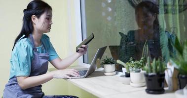 Restaurant manager surfing the web and typing on her smartphone at coffee shop . video