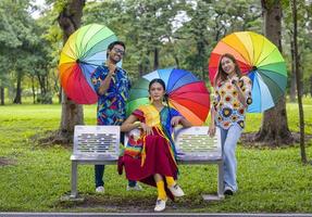 grupo de personas lgbtq vestidas con ropa colorida reunidas en el parque para expresar el concepto de movimiento fluido de género, derechos no binarios e igualdad matrimonial foto