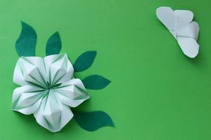 fondo de papel de origami con mariposa, flor y hojas. con lugar para texto. composición de origami. arte de papel