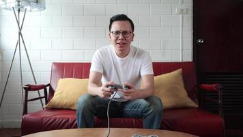 joven jugador sentado y jugando videojuegos en la consola. video