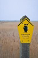 Sign National Park Core Zone on the Baltic Sea. Symbol owl with yellow background. photo