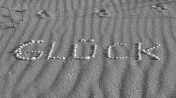 con conchas colocadas como símbolo de felicidad en la playa del mar Báltico en la arena foto