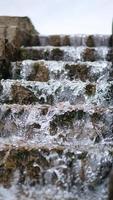 cascada sobre una escalera de piedra. un arroyo que fluye a través de un parque. foto