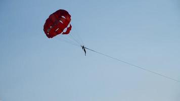 le parachute ascensionnel est un type de loisir actif. divertissement extrême pour les touristes. les gens volant en parachute large. parachute volant au-dessus de l'eau video