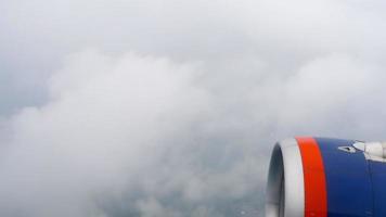 vuelo en avión a través de las nubes, vista desde la ventana del motor. espesas nubes grises fuera de la ventana del avión video