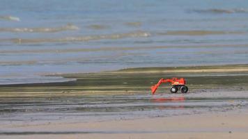 excavadora de juguete en la arena de la playa video