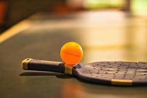 Table tennis bat with ball on a table tennis table. Pause before the game. photo