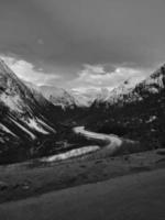 road over a pass in norway, between mountains and snow in black and white. photo